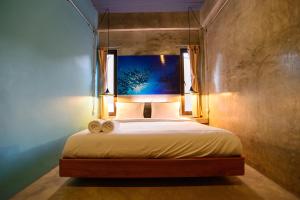 a bedroom with a bed with two towels on it at Seabox Khaolak Hostel in Khao Lak