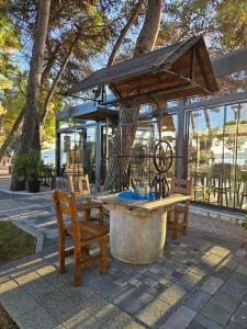 a wooden table and chairs and a bench and a building at Apartmani Linda in Vodice +20 photos