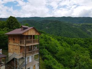 a building in the middle of a valley with trees at Gentry House in Ambrolauri