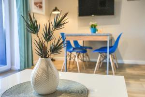 a vase with a plant in it sitting on a table at Studio 44 Baltic Park, 280m do Plaży, Duży balkon in Pogorzelica