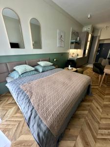 a bedroom with a large bed and two mirrors at Apartament OPAL Mickiewicza in Tarnowskie Góry