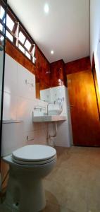 ein Badezimmer mit Toilette und Waschbecken in der Unterkunft Pousada Casa das Flores Camburi in Camburi