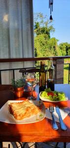 einen Tisch mit zwei Teller Essen und Salat in der Unterkunft Pousada Casa das Flores Camburi in Camburi
