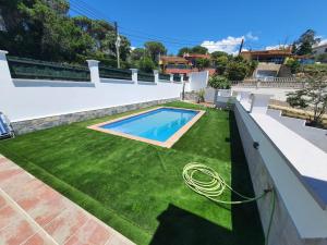 a backyard with a swimming pool and green grass at Villa Lloret de Mar 6 Personas in Vidreres