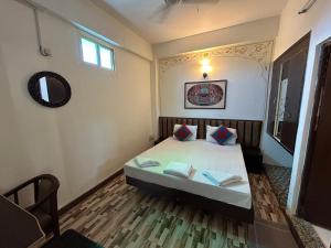a bedroom with a bed with two pillows on it at Max Guest House in Agra