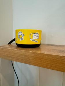 a yellow laptop computer sitting on top of a wooden shelf at A-Six Apartment luxury in Karagandy +27 photos
