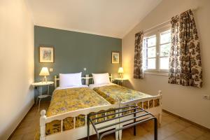 a bedroom with two beds and a window at Villehardouin Farm Estate, Studios & Apartments, Minia, Kefalonia in Argostoli