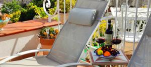 ein Stuhl mit einer Flasche Wein und einer Schale Obst in der Unterkunft RACHELE HOUSE in Amalfi