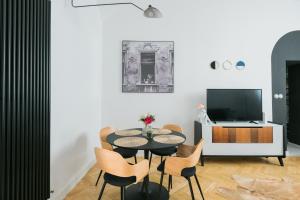 a dining room with a table and chairs and a tv at S11 Apartman in Debrecen +8 photos