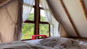 Un dormitorio con una cama y una ventana grande. en Casa Bunicilor Traditionala, en Budeni