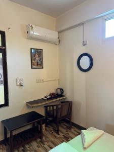 een kamer met een bureau en een tafel. bij Max Guest House in Agra