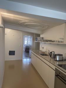 a kitchen with white cabinets and a counter top at The R Apartment Bodensee - Old Town in Schaffhausen +11 photos