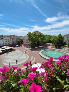 a park with a swimming pool and pink flowers at Opera Family Hotel - former City Mark hotel in Varna City