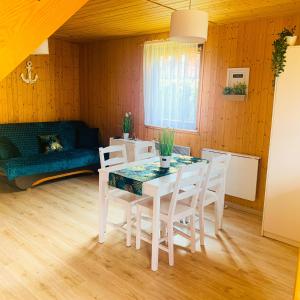 a dining room with a table and chairs and a couch at Domek letniskowy Magda in Łeba