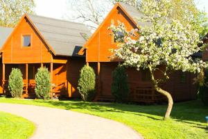 an orange house with a tree in front of it at Domek letniskowy Magda in Łeba