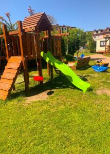 a playground with a slide and a play structure at Domek letniskowy Magda in Łeba