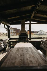 a wooden table with an outdoor stove in a building at Cazare Băile Figa -The Home DRM in Beclean