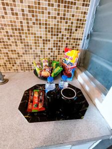 a table with snacks and water bottles on the floor at D'Marina 1 HOMESTAY LUMUT MANJUNG in Lumut