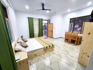 Un dormitorio con una cama y un comedor con una mesa. en Apna Ghar - Bir, en Bīr