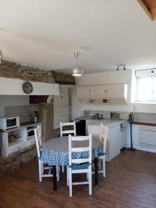 une cuisine et une salle à manger avec une table et des chaises dans l'établissement Ti an traõn le petit gîte en cœur de Bretagne, à Carhaix-Plouguer 2 autres photos