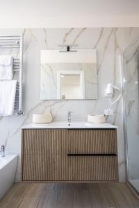 a bathroom with a sink and a mirror at Mangano Suites in Palermo +51 photos