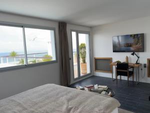 a bedroom with a bed and a desk and windows at Villa Hafa in Tangier