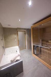 a large bathroom with a shower and a tub at Apart Alpine Retreat in Urgen