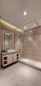 uma casa de banho com um lavatório e uma cabina de duche em vidro. em Azur One Eleven Hotel Alamein em El Alamein