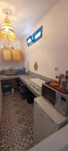 a kitchen with a counter top with a microwave at Dar jilali in Taghazout +57 photos