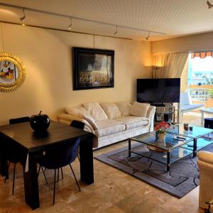 a living room with a couch and a table at Vue Mer Capitou in Mandelieu-la-Napoule