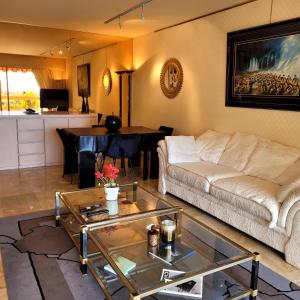 a living room with a couch and a table at Vue Mer Capitou in Mandelieu-la-Napoule