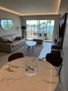 a living room with a table with a view of the ocean at Appartement Rottaro luxueux 2 ch 2 sdb face à la mer in Cannes