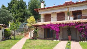a house with purple flowers on the side of it at Villa Anna III in Nea Moudania