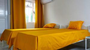 a yellow bed in a room with a window at Furnished Townhouse - Grand Baie in Grand Baie +5 photos