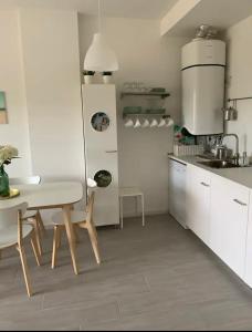 una cocina blanca con mesa y sillas. en Sunset Tarifa, 2 plantas, 6 personas, en Tarifa