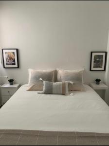 Un dormitorio con una gran cama blanca con dos mesas. en Sunset Tarifa, 2 plantas, 6 personas, en Tarifa