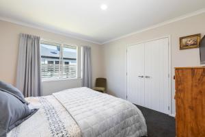 a bedroom with a bed and a window at Fabulous in Wharewaka - Wharewaka Holiday Home in Taupo