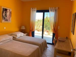 a bedroom with two beds and a large window at Villa Thea,Plaka with sea & mountain views in Kambiá +28 photos
