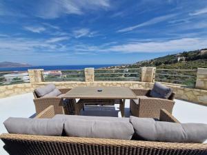 a patio with a table and chairs and the ocean at Villa Thea,Plaka with sea & mountain views in Kambiá