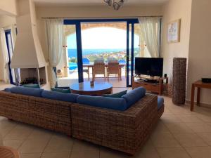 a living room with a blue couch and a television at Villa Thea,Plaka with sea & mountain views in Kambiá