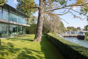 un albero di fronte a un edificio vicino a un fiume di La Réserve Genève Hotel & Spa a Ginevra