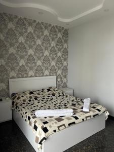1 cama con edredón blanco y negro en un dormitorio en Brilliant712, en Kobuleti