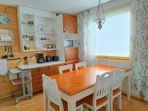 a kitchen with a wooden table and chairs at Apartment Nilsiä in Nilsiä