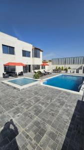 a building with a swimming pool in front of a building at Ayla Chalets in Amman