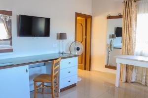a room with a desk with a tv and a mirror at Madonnina Homestay in St Julian's