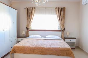 a bedroom with a bed and a window with a chandelier at Madonnina Homestay in St Julian's
