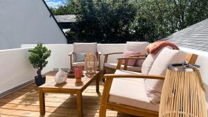 eine Terrasse mit zwei Stühlen und einem Tisch auf einem Balkon in der Unterkunft Le Aristide - Centre Ville - Calme - Terrasse in Saint-Nazaire