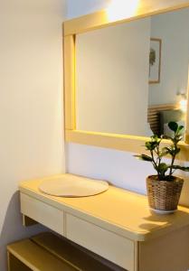 a bathroom with a yellow mirror and a plant on a counter at Lemon Art Hotel Apartments in Tolo