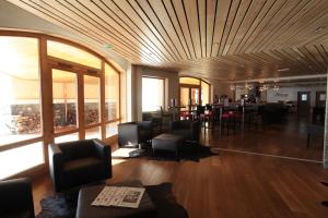 a lobby with chairs and tables and a restaurant at Le Chalet du Mont Vallon Spa Resort in Les Menuires