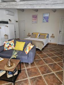 a living room with a bed and a couch at Gîte Le Refuge in Monieux